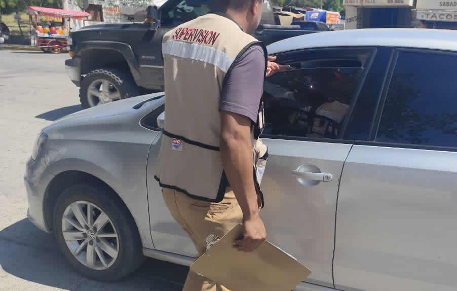 Inspector de la Subsecretaría del Transporte coloca calcomanía verde en unidad de plataforma durante operativo en Ciudad Victoria