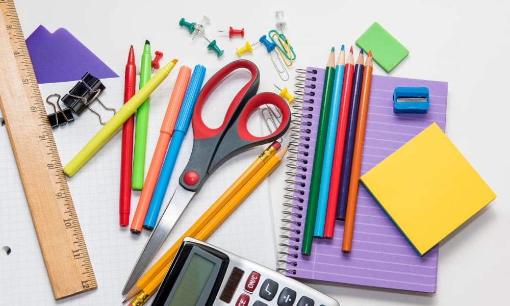 Útiles escolares y mochila sobre escritorio, representando el gasto por regreso a clases en Tamaulipas